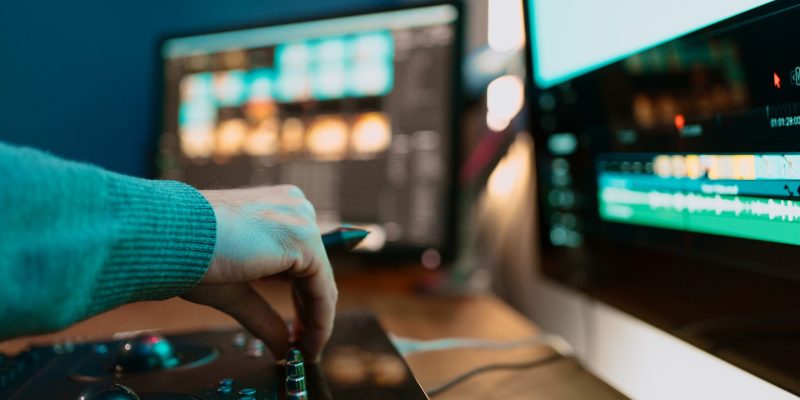 Male Video Editor hand Works with Footage or Video on His Personal Computer, he Works in Creative Office Studio or home. Neon lights